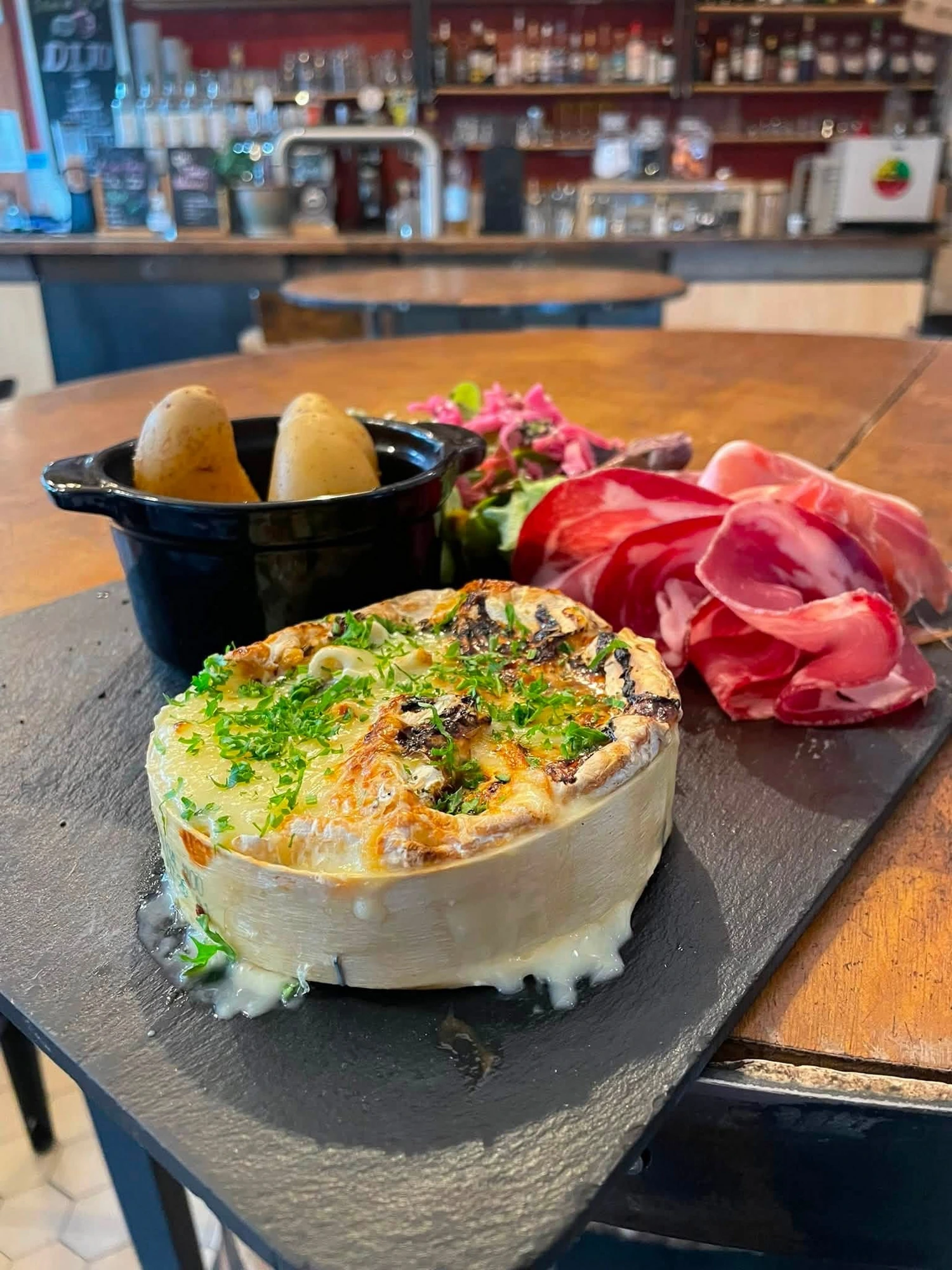 Baked camembert with cured ham and potatoes