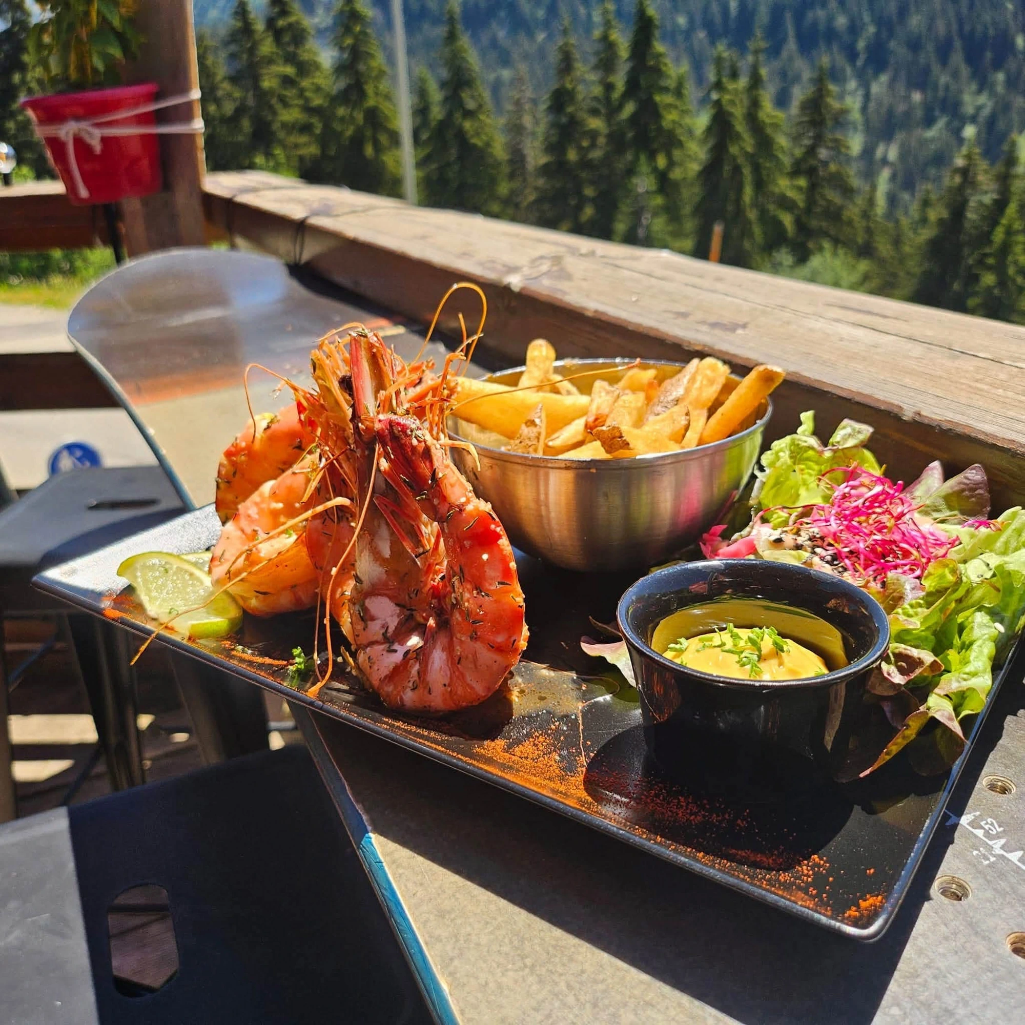 Gambas grillées, frites maison et salade servies en terrasse
